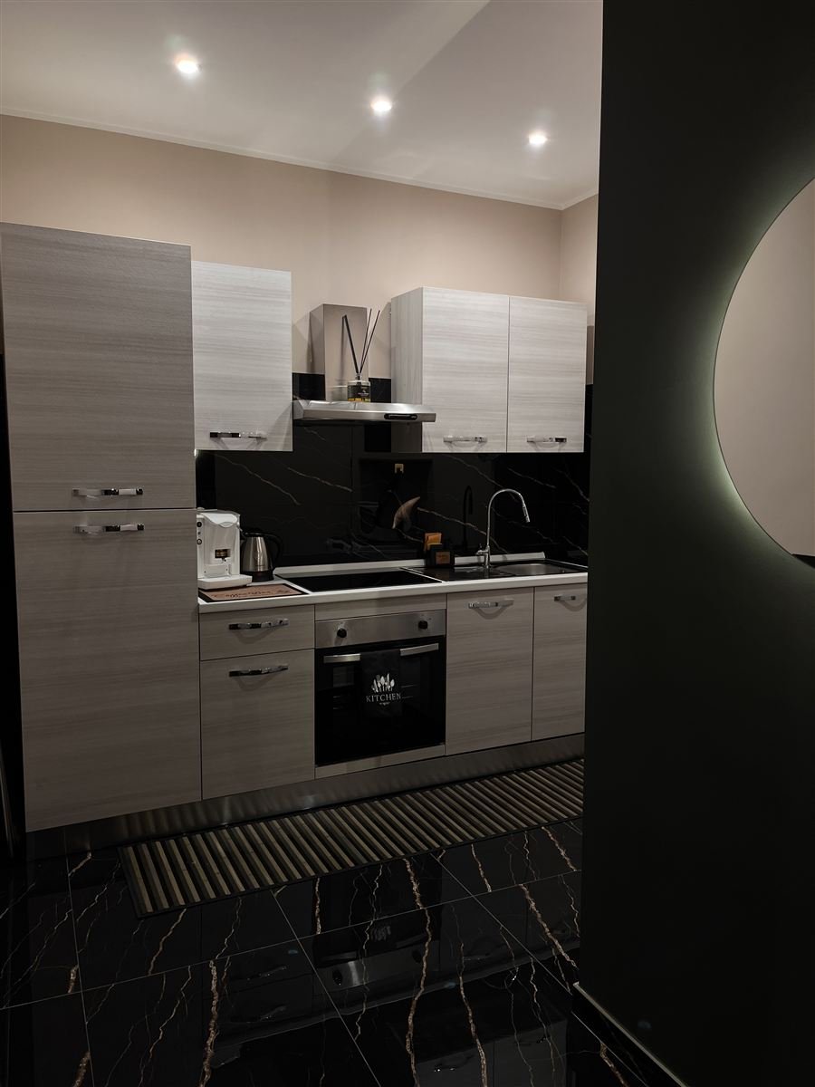 Cucina attrezzata con piano cottura, forno e frigorifero